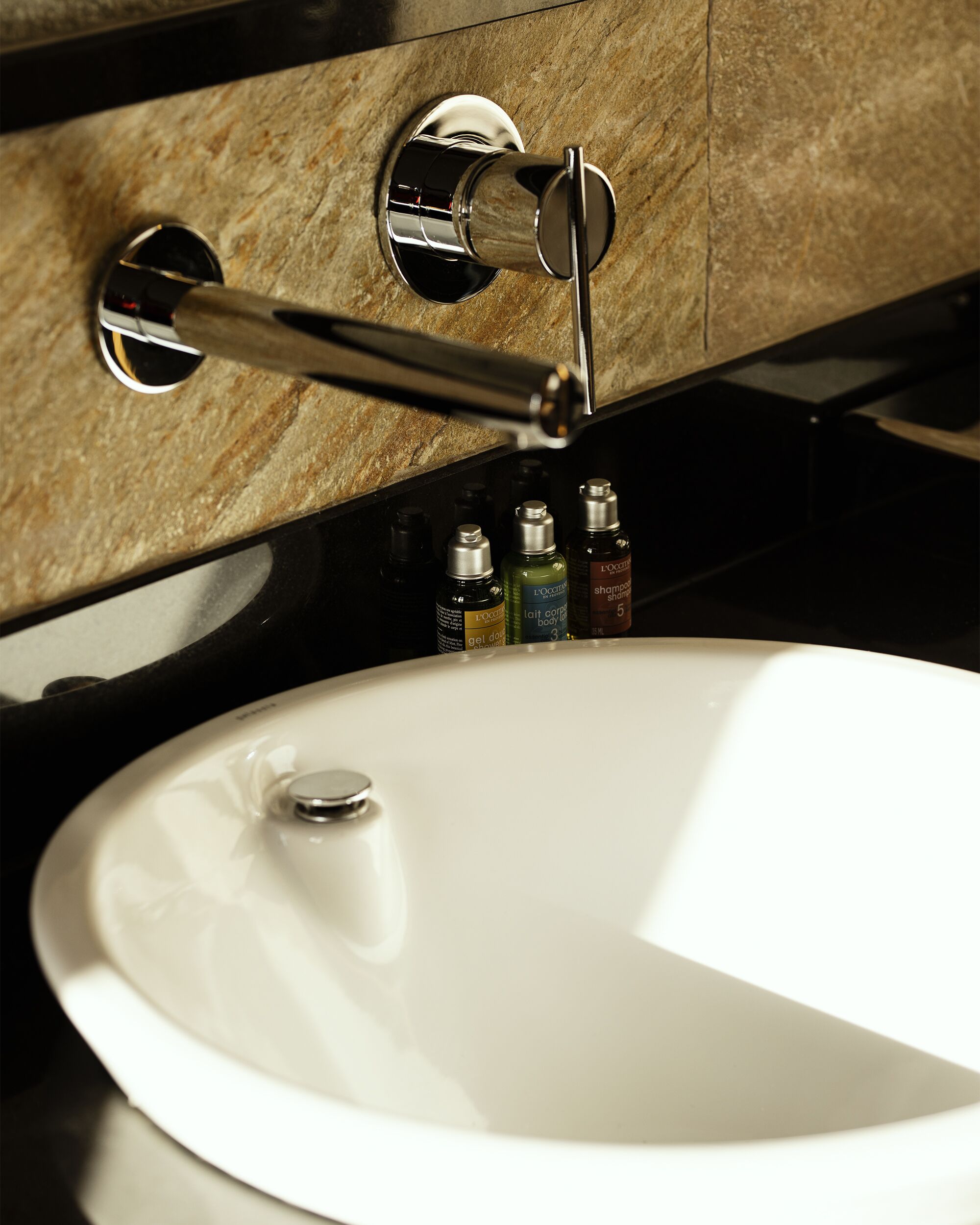A bathroom sink with a chrome faucet and a mirror above it.