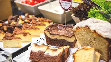 A buffet with various desserts including cakes and pastries.