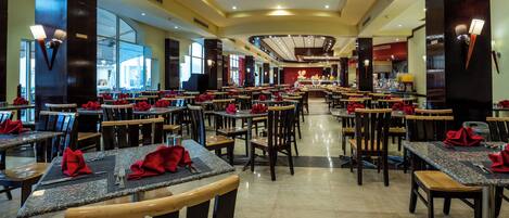 A spacious restaurant with multiple dining tables and chairs, arranged in a linear fashion.