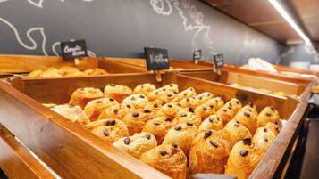 A bakery display with pastries in wooden trays.