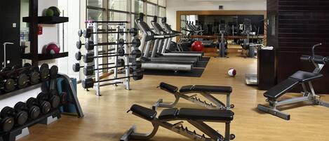 A gym with weightlifting equipment, treadmills, and exercise machines.