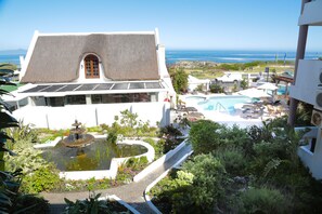 A resort with a pool, a fountain, and a view of the ocean. - Misty Waves Boutique Hotel (Hermanus)