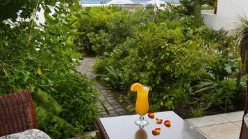 Relax in a serene outdoor space with unobstructed ocean views, comfortable seating, and lush greenery surroundings.