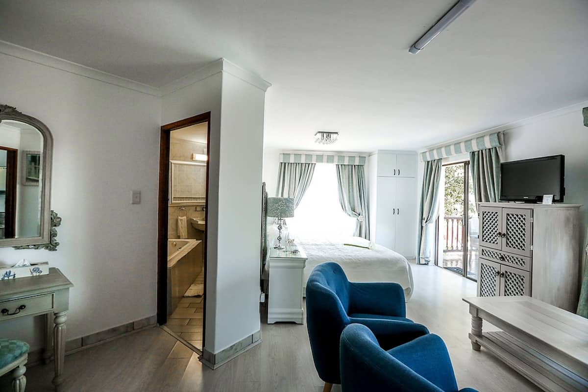 Une chambre d’hôtel équipée d’un lit, d’un bureau, d’une chaise, d’une télévision, d’une armoire et d’une salle de bain.