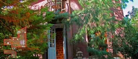 Ein Haus mit Balkon, Steinmauer und Garten.