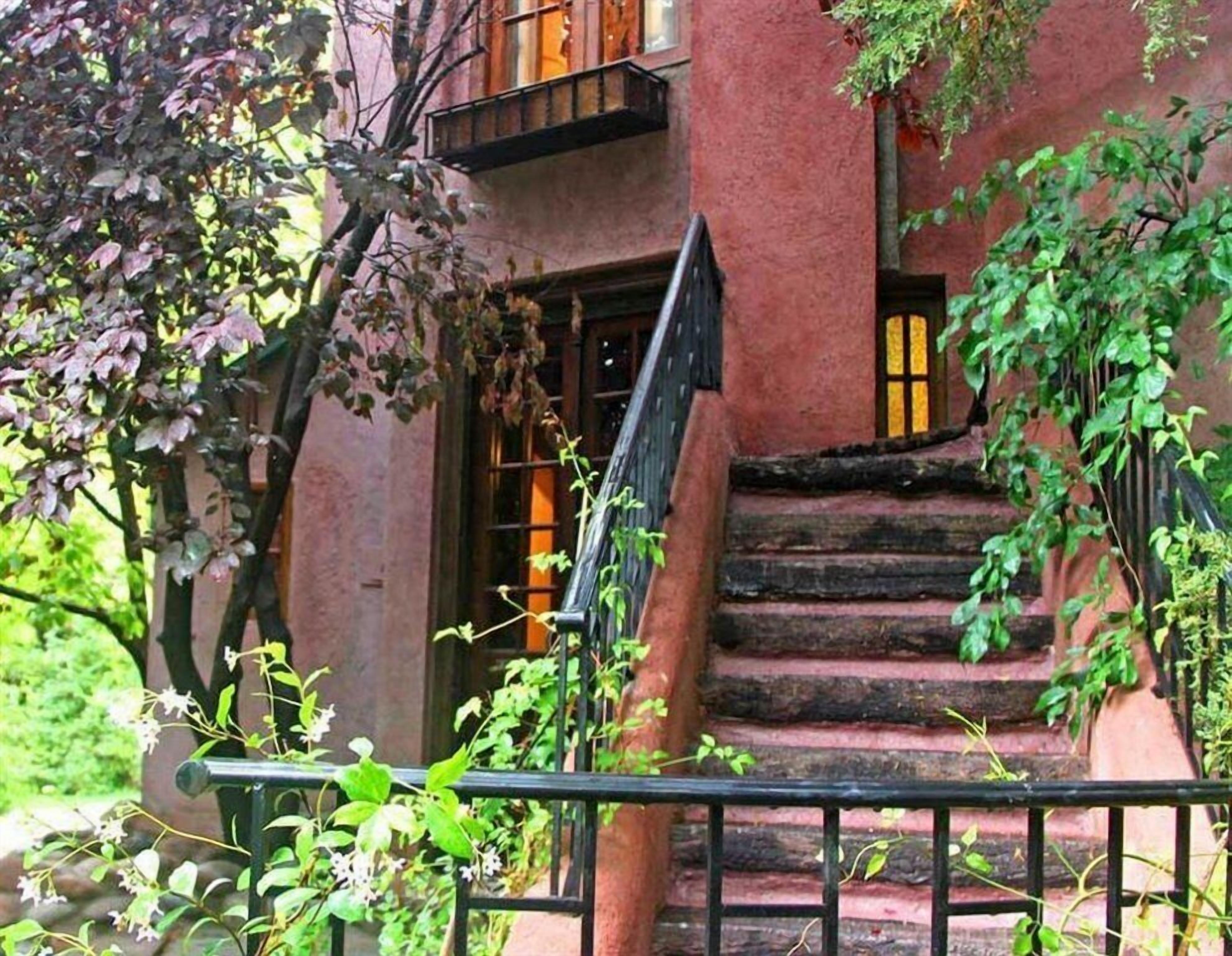 A red brick building with a staircase leading to a second-floor entrance.