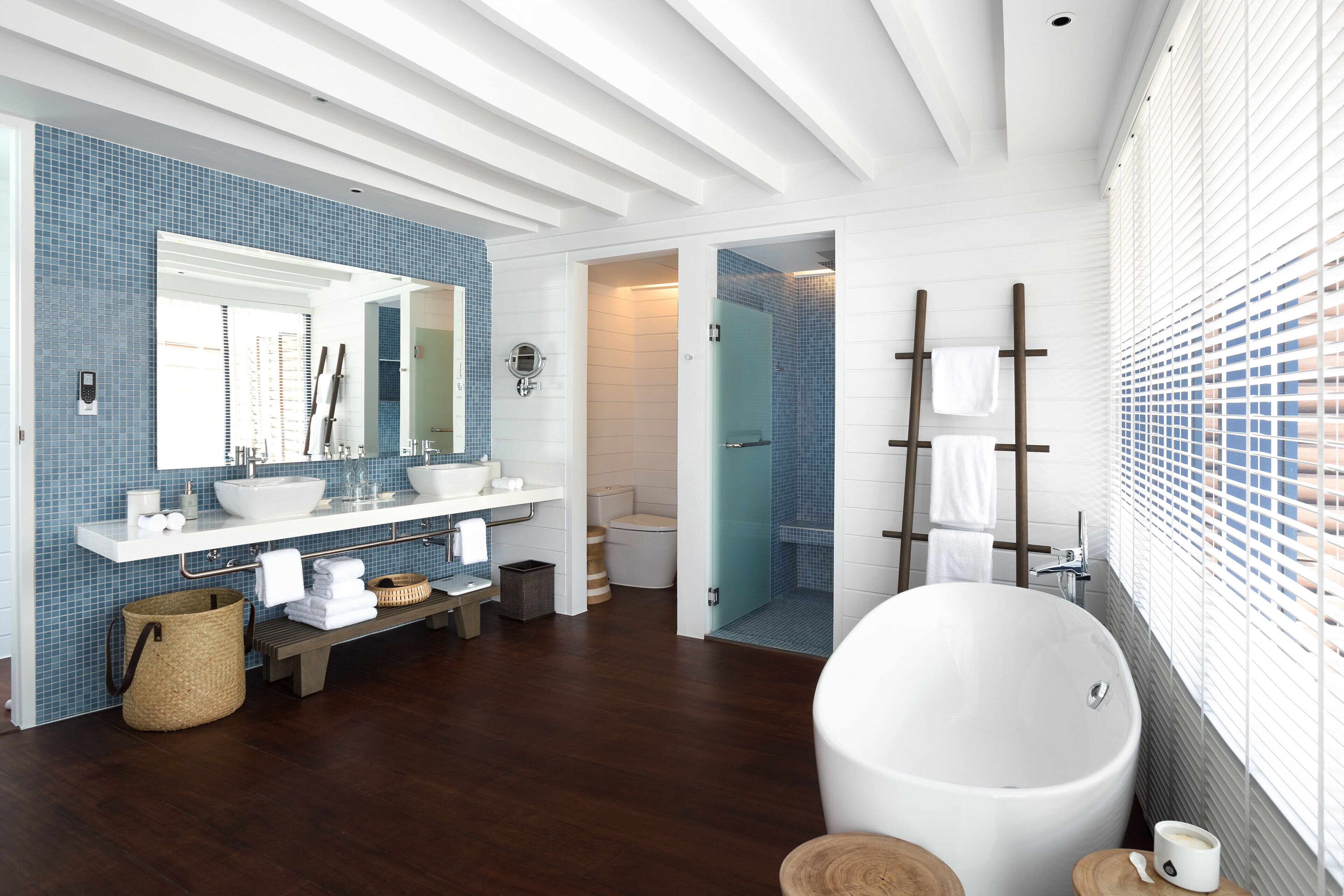 Un baño moderno con una bañera grande, un tocador doble y ducha a pie.