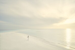 On the beach, white sand, sun loungers, beach umbrellas