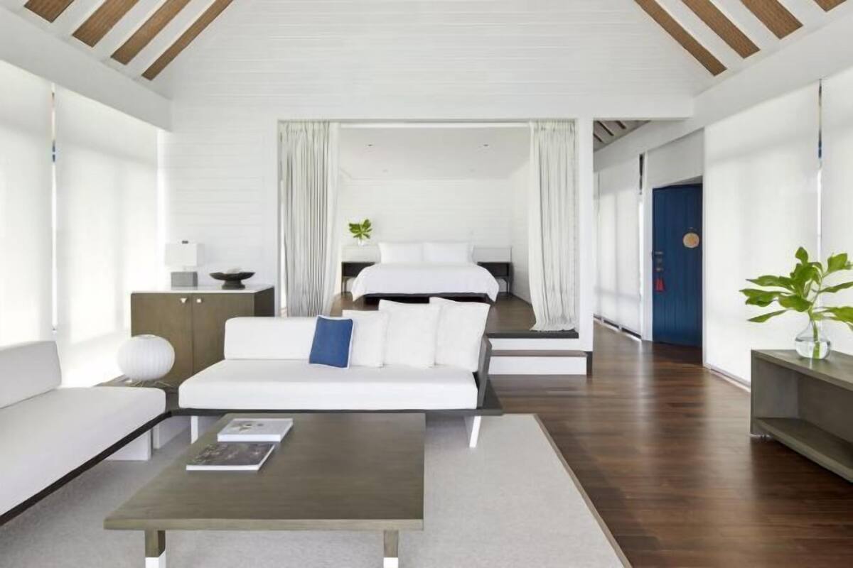 Ein modernes Hotelzimmer mit Bett, Sofa, Couchtisch und Schreibtisch.
