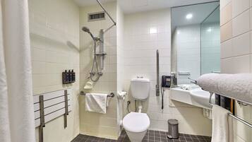 A bathroom with a shower, toilet, and sink.