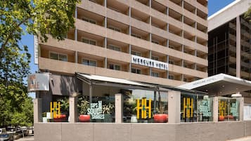 A multi-story hotel with a sign reading 'Mercure Hotel.'