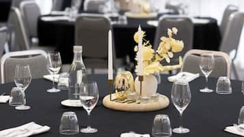 A dining table set with wine glasses, a bottle, and a candle centerpiece.