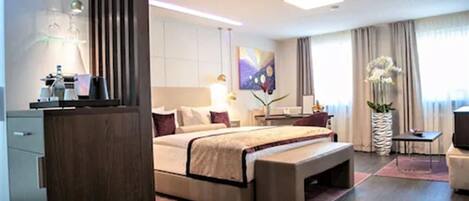 A modern hotel room with a large bed, bedside tables, a desk, and a chair.