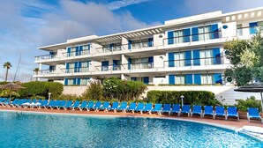 A hotel with a pool, blue chairs, and a clear sky. - Marina Club Suite Hotel (Lagos)