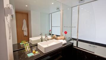 Un baño moderno con dos lavabos, un espejo grande y una cabina de ducha de vidrio.