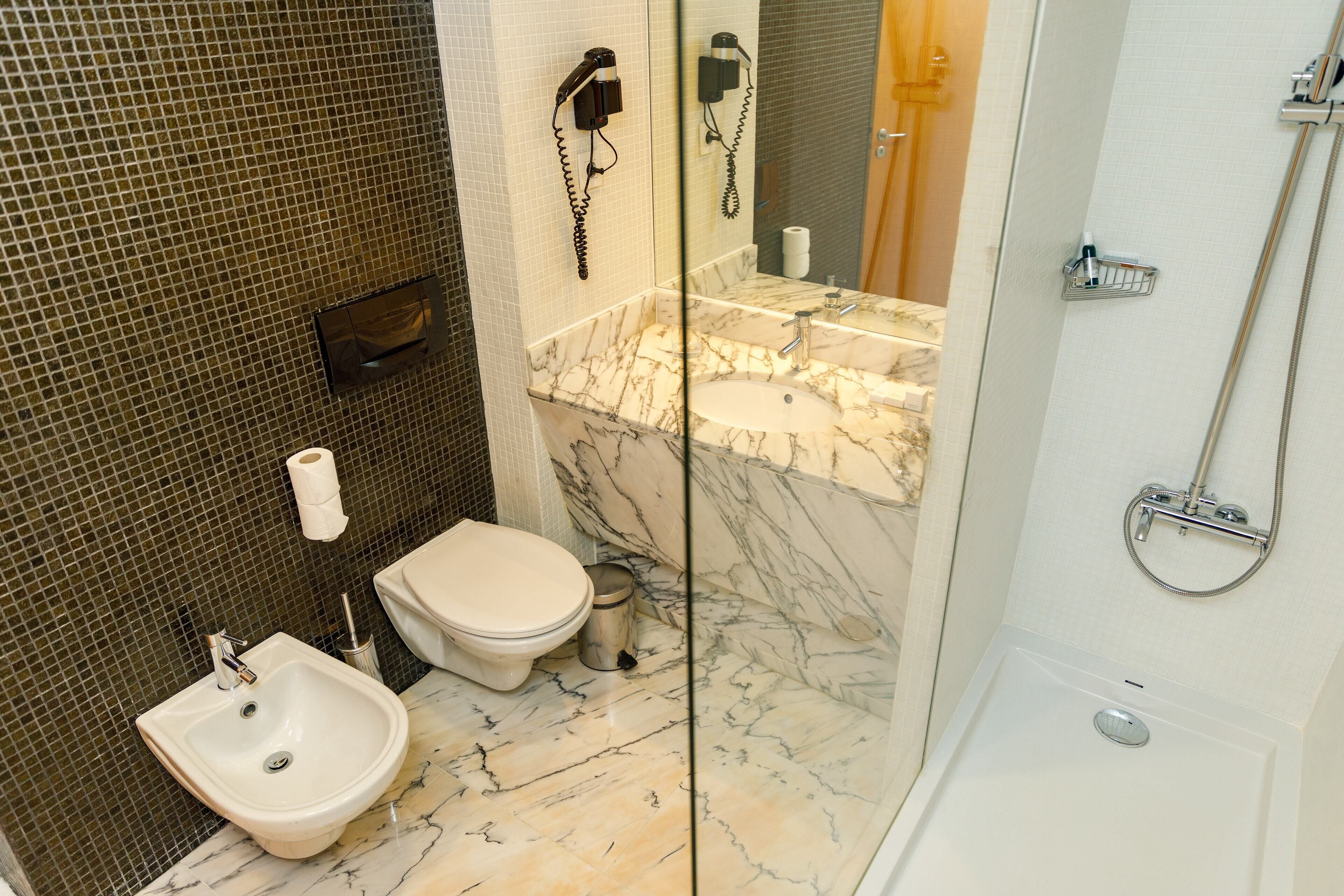 Un baño con bidé, inodoro y lavamanos.