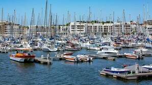 A marina with numerous boats docked, a clear sky, and buildings in the background. - Marina Club Suite Hotel (Lagos)