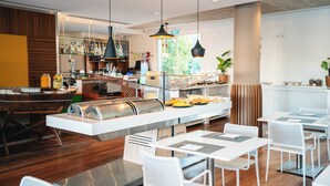 A modern restaurant with a bar area, white tables, and a buffet counter. - Marina Club Suite Hotel (Lagos)