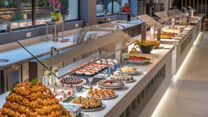 A buffet with various food items and a large display of crepes.