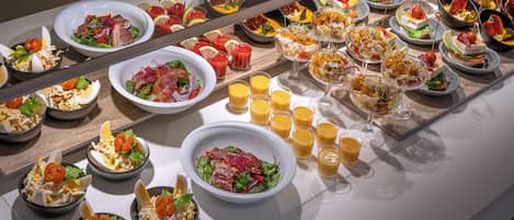 A buffet with various dishes and drinks.