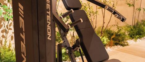 A gym equipment named 'IETENON' with a bench and weight plates.