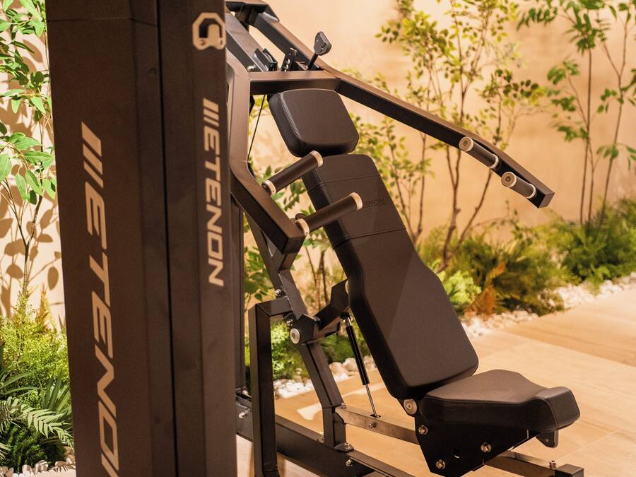 Equipo de gimnasio que incluye 'IETENON', una banca y discos de pesas.