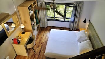 Habitación de hotel con cama, escritorio y armario.