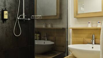A modern bathroom with a glass-enclosed shower, a wooden vanity, and a large mirror.
