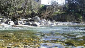 Un riu d'aigua cristal·lina, envoltat de roques i vegetació escassa.