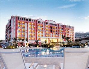 A multi-story hotel with balconies, a swimming pool, and outdoor seating. - Hotel Bonalba Alicante (Mutxamel)