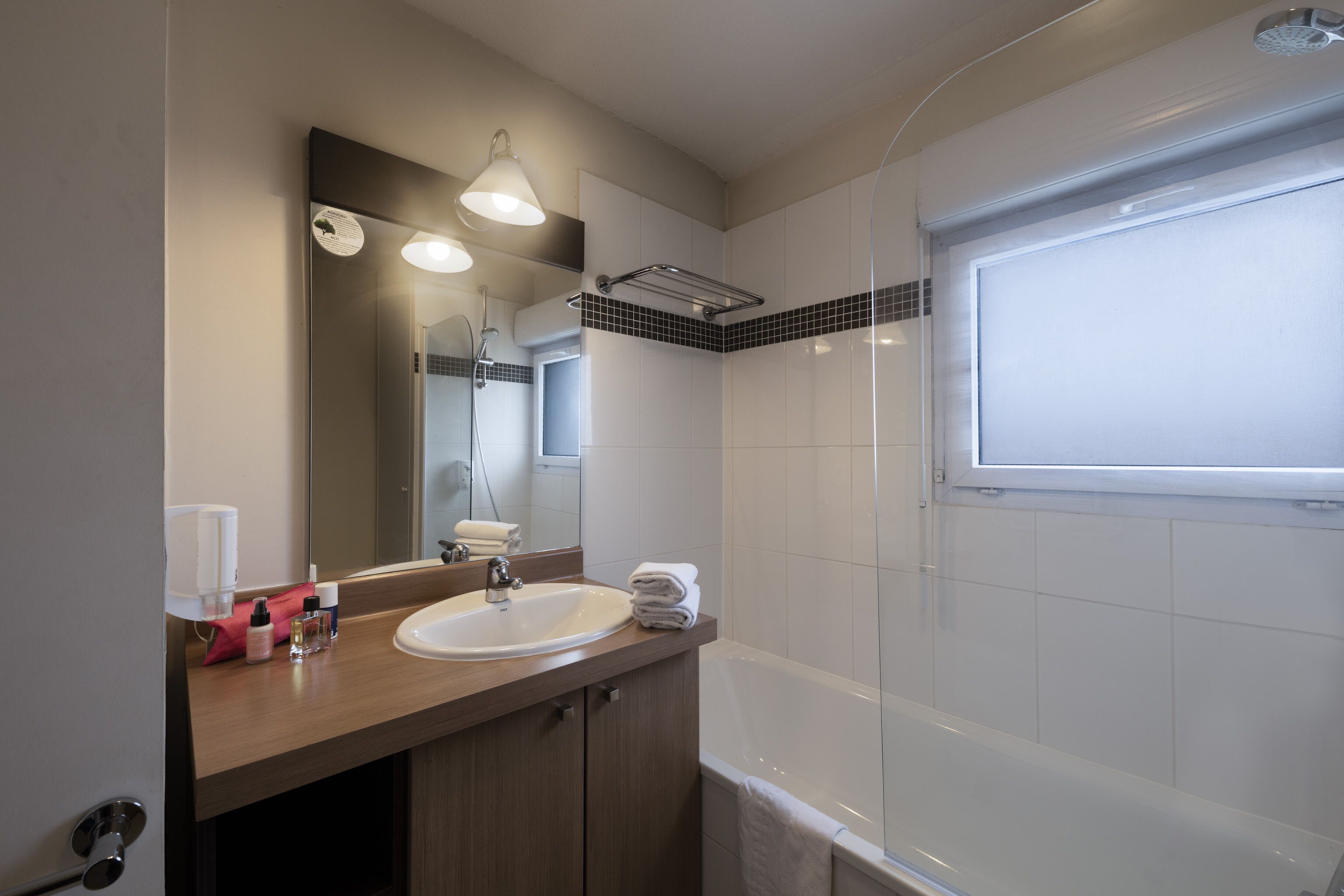Une salle de bain moderne avec un lavabo, un miroir et une douche.