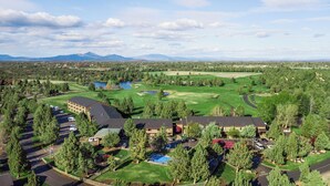 An aerial view of a resort with multiple buildings, a golf course, and a lake. - The Lodge at Eagle Crest Resort (Redmond)