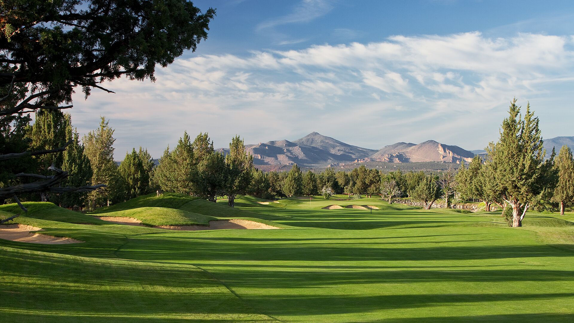 A golf course with a clear view of mountains in the background.