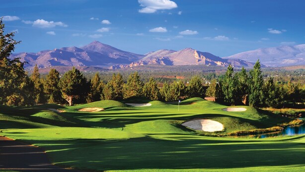 A golf course with a mountain backdrop, clear skies, and a flagstick. - The Lodge at Eagle Crest Resort (Redmond)
