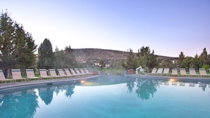 A clear swimming pool with lounge chairs and a view of a residential area in the background. - The Lodge at Eagle Crest Resort (Redmond)