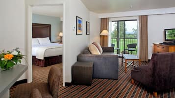 A hotel room with a bed, a sofa, a desk, and a television.