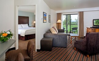 Ein Hotelzimmer mit Bett, Sofa, Schreibtisch und Fernseher.