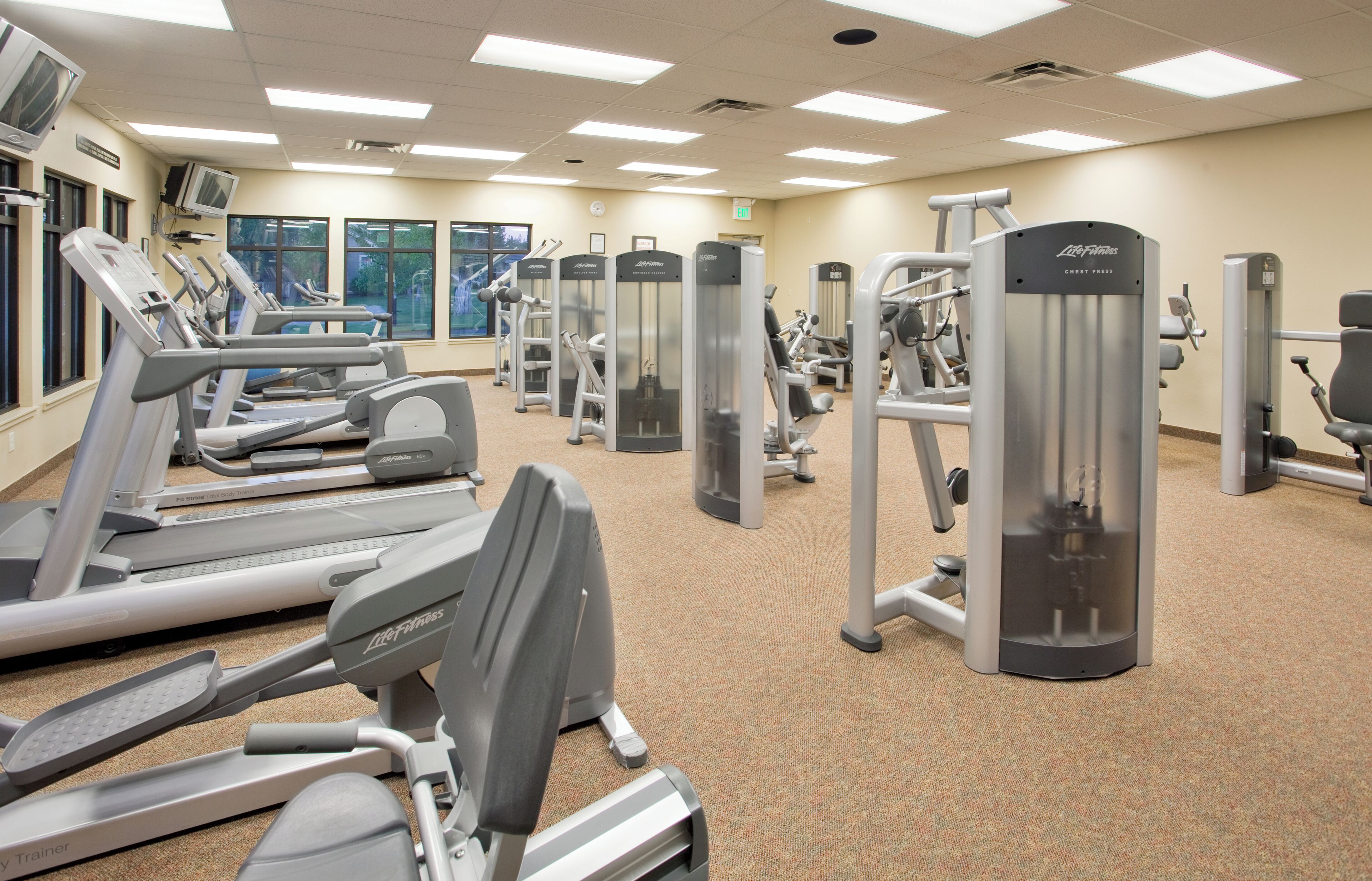 A gym with treadmills, weight machines, and exercise equipment.