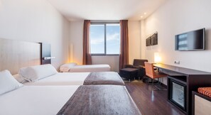 A hotel room with two beds, a desk, a chair, a television, and a window with curtains. - Hotel ILUNION Aqua 4 (Valencia)