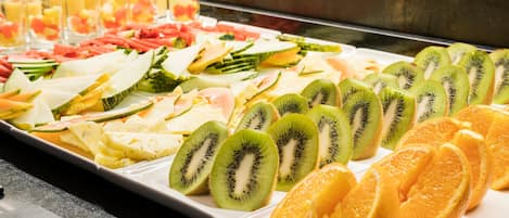 A buffet with various fruits and juices.