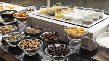 Un bufé con diferentes opciones de comida, incluyendo frutos secos, frutas deshidratadas y bebidas.