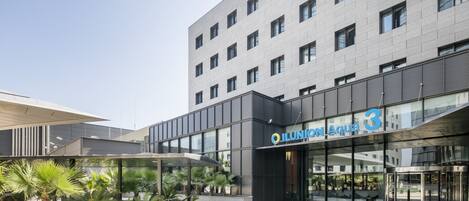Un edificio moderno con fachada de vidrio y un letrero que dice "Ilunion Aqua 3".