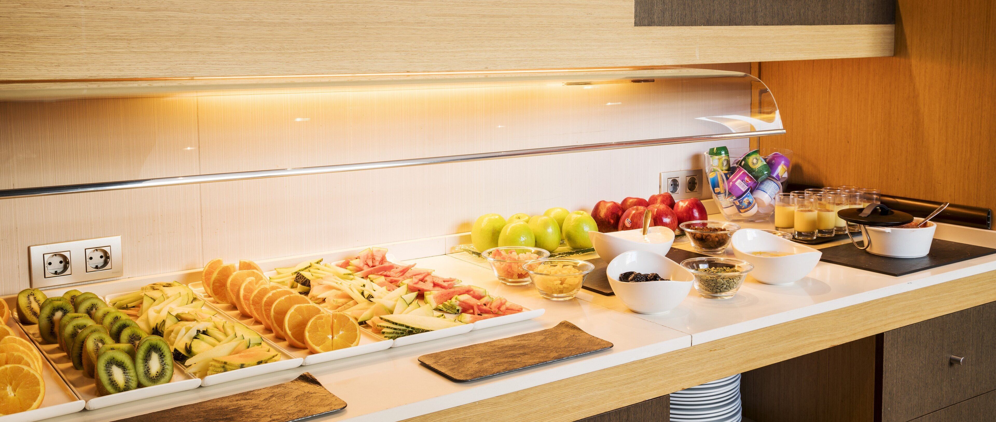 A buffet with various fruits, vegetables, and prepared foods.