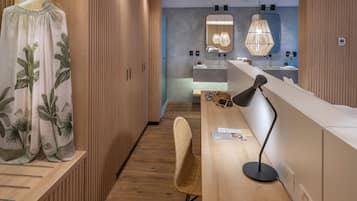 Un baño moderno con armarios de madera, un espejo grande y una lámpara colgante elegante.