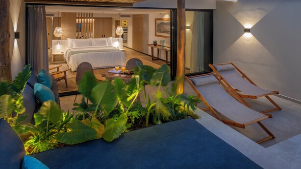 A modern hotel room with a large bed, a sitting area with a coffee table, and a balcony with a lounge chair. - Serhs Natal Grand Hotel & Resort (Natal)