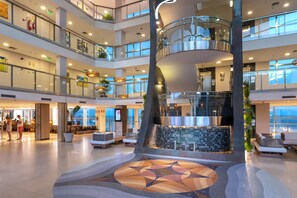 A multi-level atrium with a central spiral staircase, seating areas, and a decorative floor pattern. - Serhs Natal Grand Hotel & Resort (Natal)