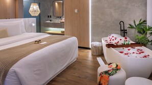 A modern hotel room with a large bed, a sitting area with a bathtub, and a small table with toiletries. - Serhs Natal Grand Hotel & Resort (Natal)