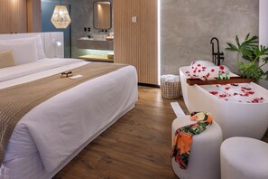 A modern hotel room with a large bed, a sitting area with a bathtub, and a small table with toiletries. - Serhs Natal Grand Hotel & Resort (Natal)