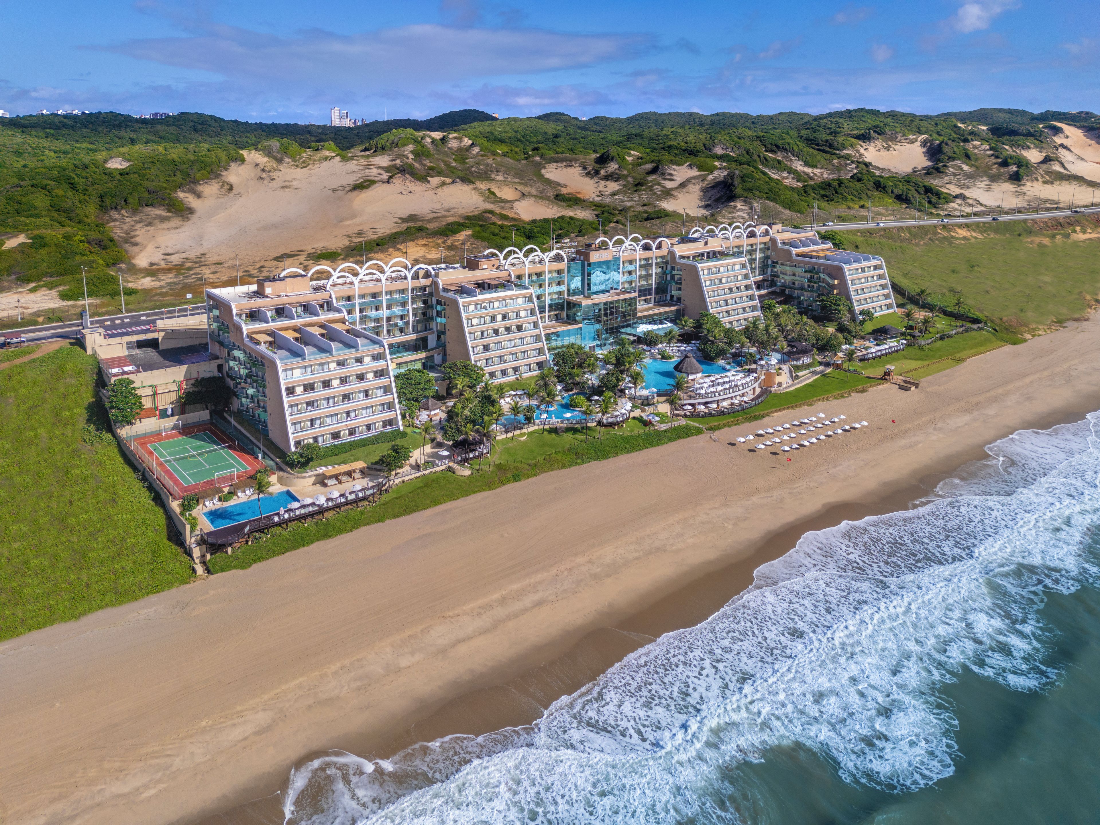 Resort com vários edifícios, uma praia e área de piscina.