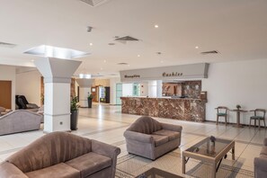 A spacious lobby with a reception desk, seating area, and a modern design. - Antigoni Hotel (Paralimni)